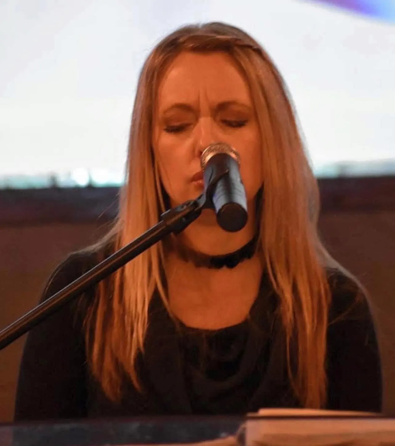 Worship leader singing during a service at The River Church